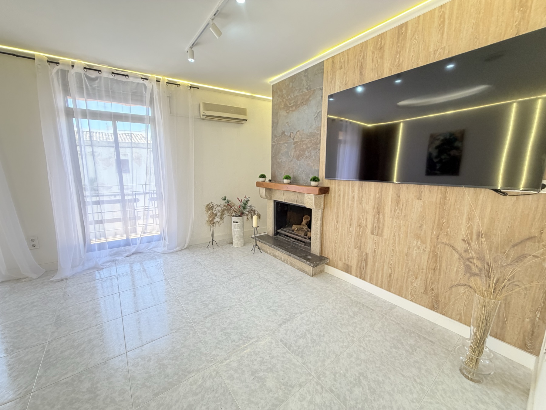 Jasny salon z kominkiem w domu w centrum Gandii
